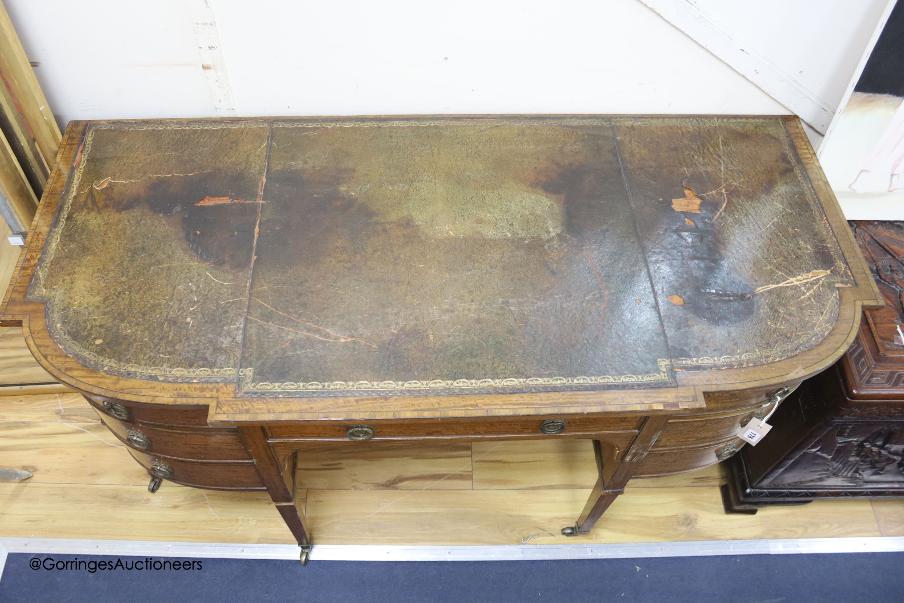 An Edwardian banded breakfront kneehole desk, length 142cm, depth 63cm, height 75cm